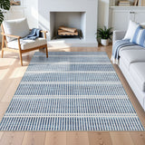 Blue and white striped area rug on light wood floor in a living room with sofa and chair
