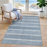 Blue and white striped area rug on light wood floor near chair and window