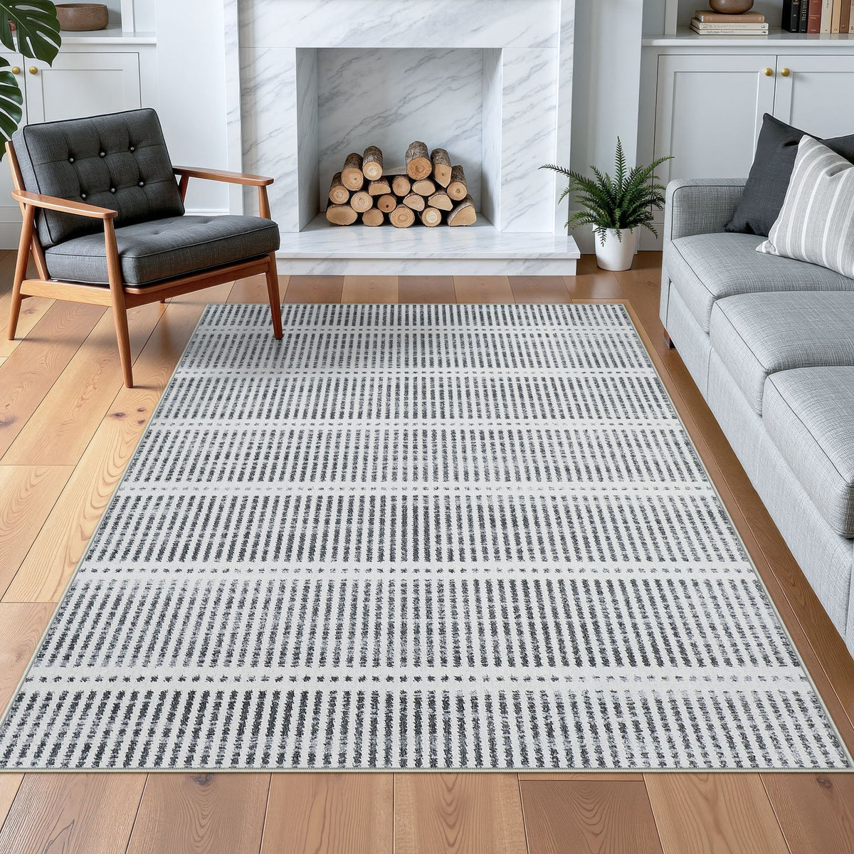 Gray and white striped area rug on hardwood floor in living room with sofa and chair