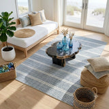 Blue and white striped area rug on wooden floor in a sunlit living room