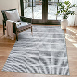 Black and white striped area rug on hardwood floor near chair and glass door