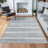 Gray and white striped area rug on hardwood floor in living room with sofa and chair