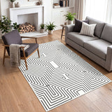 Black and white geometric patterned area rug on wooden floor in a living room with sofa and chair