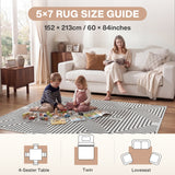 Black and white geometric rug on wooden floor with children playing and woman reading on sofa, 5x7 size guide shown