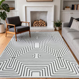 Black and white geometric patterned area rug on hardwood floor in modern living room
