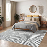 Black and white geometric rug on wooden floor in bedroom with bed and window
