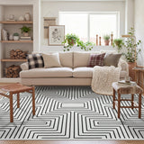 Black and white geometric patterned area rug on wooden floor in a living room