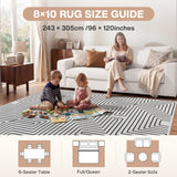 Black and white geometric rug on wooden floor with two children playing and woman reading on sofa