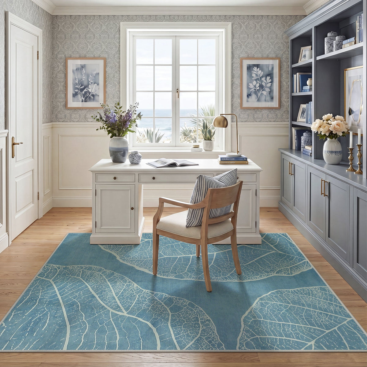 Blue leaf pattern area rug on wooden floor in a sunlit home office with white desk and chair