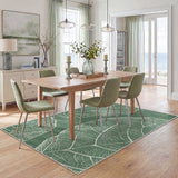 Green leaf pattern rug on wooden floor in dining room with table and chairs