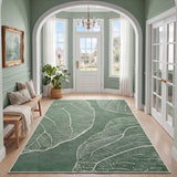 Green leaf pattern rug on hardwood floor in arched entryway with white trim and potted plant