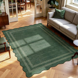 Scalloped green area rug with checkered border on wooden floor in living room