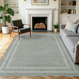 Scalloped grey area rug with white geometric border on wooden floor in living room