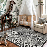 Black and white zebra print rug on wooden floor in a nursery with crib and giraffe shelf