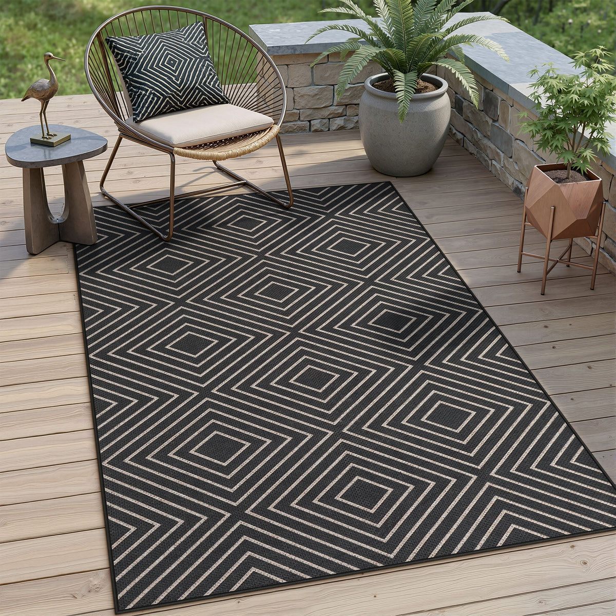 Black and beige geometric patterned jute rug on wooden deck with chair and potted plants