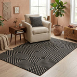 Black and beige geometric patterned jute area rug on light wood floor in living room