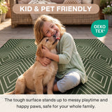 A child hugs a dog on a green geometric patterned rug in a patio setting