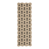Beige jute runner rug with black floral pattern, scalloped edges, shown flat