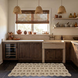 Beige floral jute rug on dark tile floor in rustic kitchen