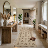 Beige floral jute runner rug on tiled floor in hallway with wooden console and potted plants