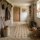 Beige floral jute runner rug on stone floor in rustic hallway