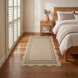 Scalloped beige jute rug on hardwood floor in bedroom with bed and window