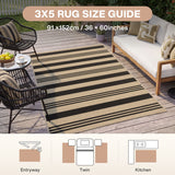 Striped jute rug 91x152cm in beige and black, shown on wooden deck with outdoor furniture