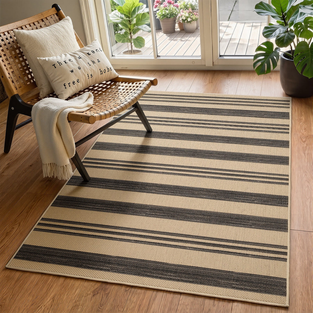 Beige and dark gray striped jute rug on hardwood floor near wicker chair and glass door