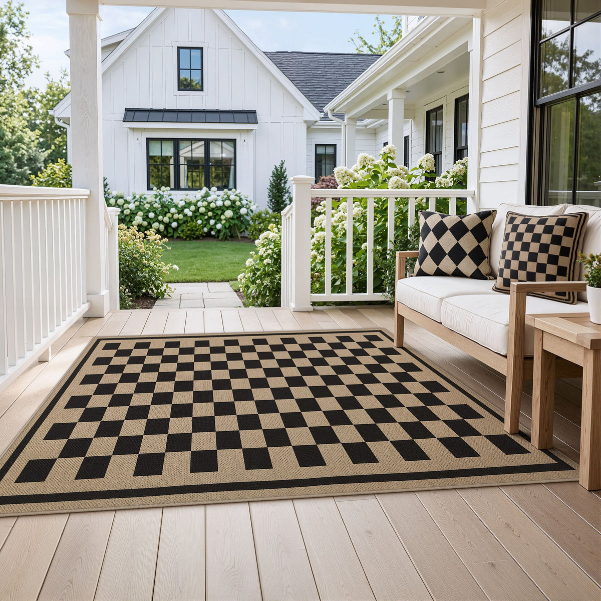 Black and beige checkered jute rug on wooden porch with outdoor sofa