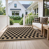 Black and beige checkered jute rug on wooden porch with outdoor sofa