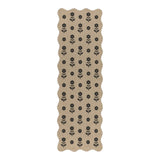 Beige jute runner rug with black floral pattern, shown flat on floor