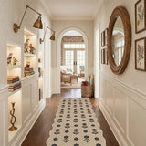 Black floral patterned jute runner rug on hardwood floor in hallway