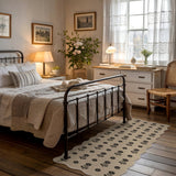 Black floral patterned jute runner rug on wooden floor in bedroom