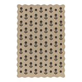 Beige jute rug with black floral pattern, scalloped edges, shown flat