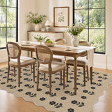 Black floral pattern on beige jute rug in dining room with wooden table and chairs