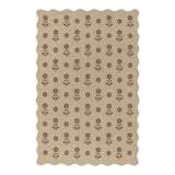 Beige jute rug with brown floral pattern, scalloped edges, shown flat