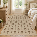 Beige jute runner rug with black floral pattern, scalloped edges, shown in bedroom on wooden floor