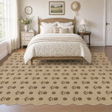 Beige jute rug with black floral pattern, scalloped edges, shown in bedroom on wooden floor