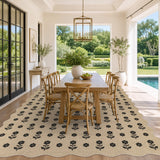 Black floral pattern on beige jute rug under wooden dining table in sunlit room