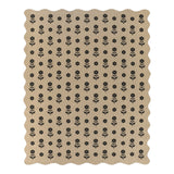 Beige jute rug with black floral pattern, scalloped edges, shown flat