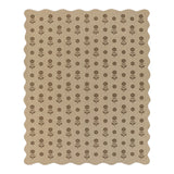 Beige jute rug with black floral pattern, scalloped edges, shown flat