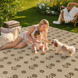 A beige jute rug with brown floral pattern, shown outdoors with a woman, child, and dog