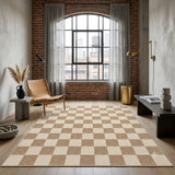 Beige and cream checkered area rug on wooden floor in a room with brick wall and large window