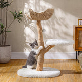A grey and white cat climbs a 35" tall wooden cat tree with a wicker basket bed and faux fur platforms