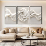 Three large black-framed abstract canvas artworks with 3D textured swirls, mounted above a beige sofa in a living room