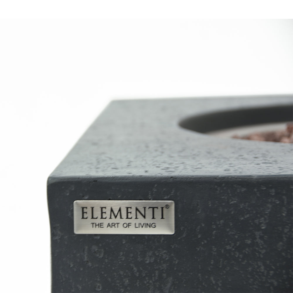 Close-up of dark grey fire pit table corner with 'ELEMENTI THE ART OF LIVING' label