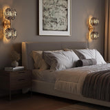 Gold wall sconce with two textured smoke glass globe lights mounted on bedroom wall