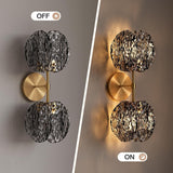 Gold wall sconce with two textured smoke glass globes, shown off and on