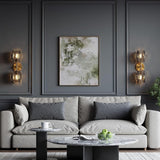 Gold wall sconce with two textured smoke glass globe lights mounted on dark grey wall