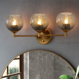 Gold bathroom vanity light with three gray crackle glass shades mounted above a round mirror